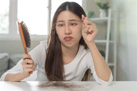 Serious, worried asian young woman, girl holding brush, show her comb