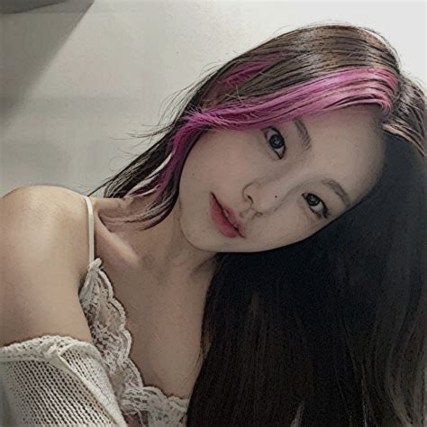 a woman with pink hair is posing for the camera