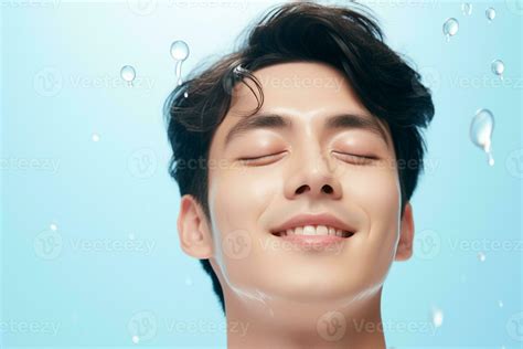 Handsome Asian man washing face with copy space on solid pastel ...