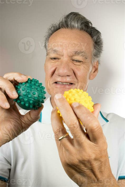 Mature man holding and squeezing massage therapy spike balls 24669571