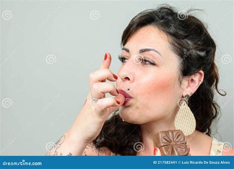Closeup of Tattooed Woman Licking Her Fingers and Holding a Brazilian