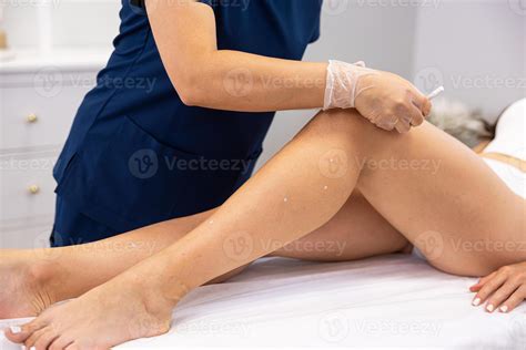 Professional beautician marking birthmarks with a white pencil during a