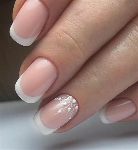 a woman's hand with french manies and white flowers on the tip of her nails