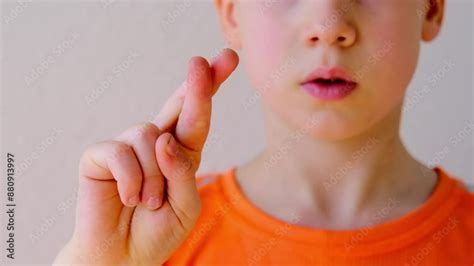 Close-up of child's crossed fingers for luck, 9-year-old boy making ...
