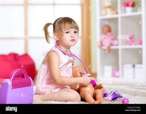 Little girl playing with dolls in hospital Stock Photo - Alamy