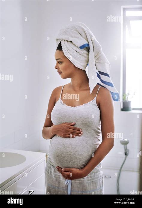 Blessed with the pregnancy glow. a pregnant young woman standing in the ...
