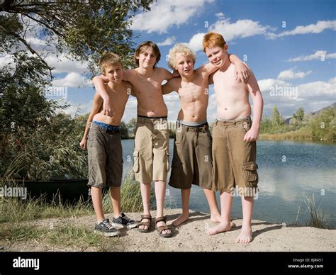 four boys playing by a lake Stock Photo - Alamy