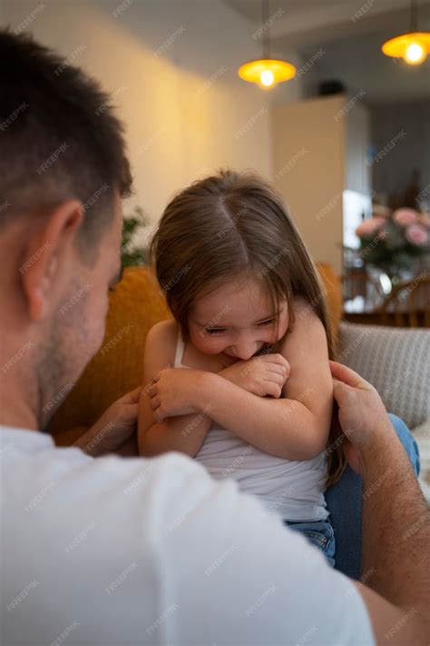 Free Photo | Father making his daughter laugh by tickling her