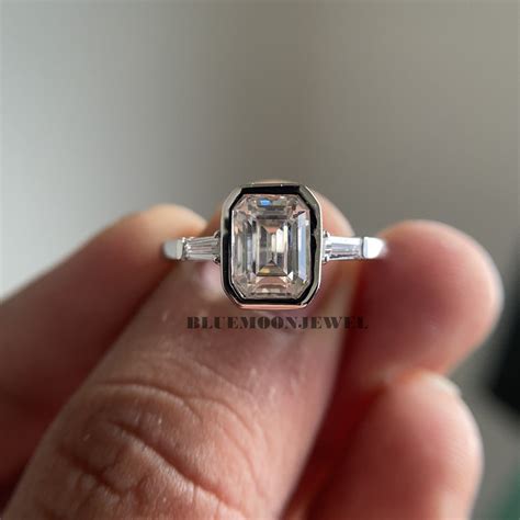 emerald bezel set  stone ring tapered baguette diamond side stone