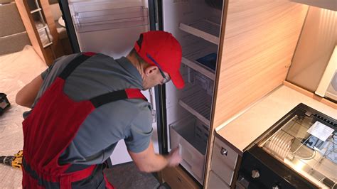 RV Recreation Vehicles Technician Checking Travel Trailer Refrigerator