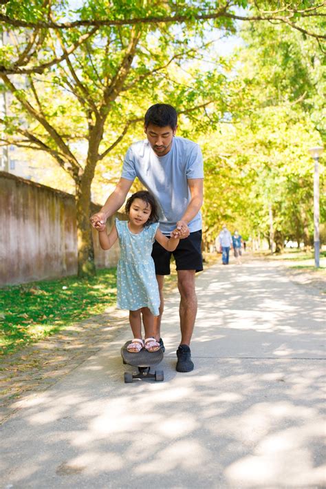 Free Photo | Portrait of asian father and his daughter skateboarding in
