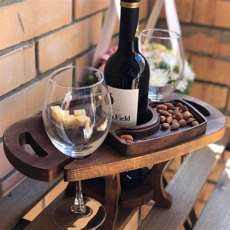 a bottle of wine and two glasses on a wooden table with a brick wall in ...