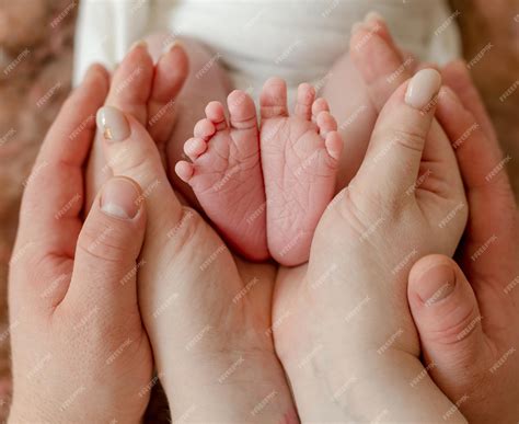 Premium Photo | Newborn baby feet in parents hands