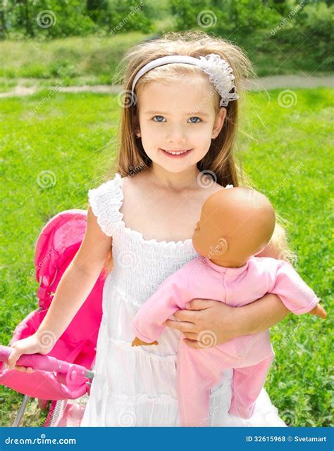 Cute Little Girl with Her Toy Carriage and Doll Stock Photo - Image of