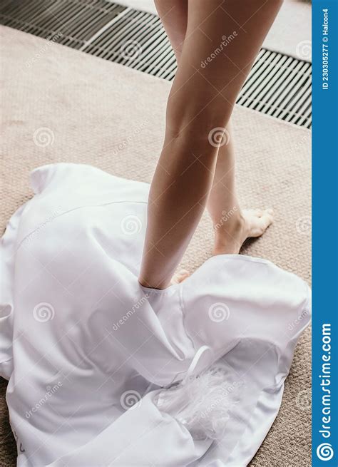 Female Bare Feet Close-up and White Robe on the Floor in a Hotel Room ...