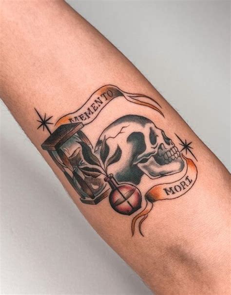 a person with a tattoo on their arm holding a glass filled with liquid ...