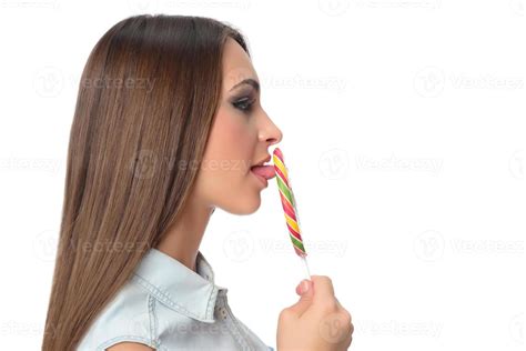 woman licking sweet candy. Female model eating delicious confectionery ...