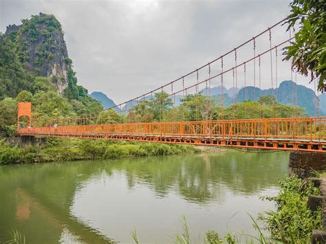puente colgante cruza el río nam song en la cueva tham chang vangvieng