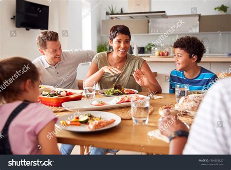 multi generation mixed race family eating meal stock photo