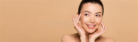 attractive cheerful nude asian girl applying oil  face stock photo