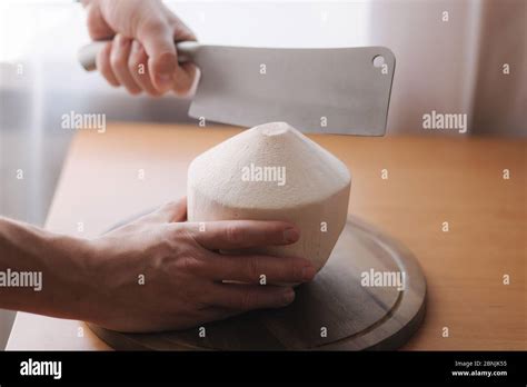 Man use machete knife to open coconut at home Stock Photo - Alamy