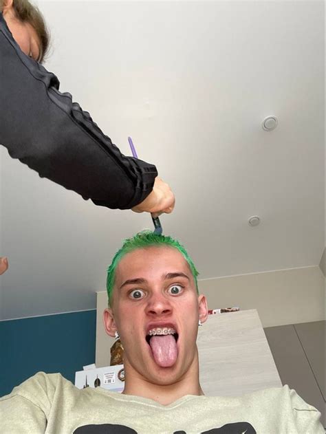 a man with green hair is getting his hair cut by another person in the ...