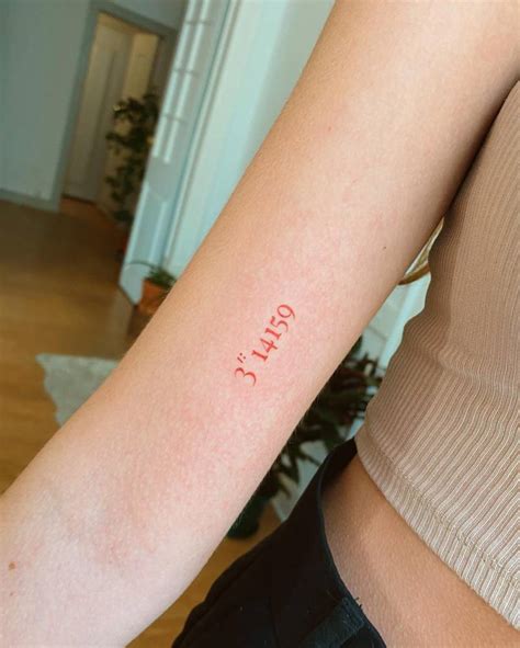 Number of Pi tattooed on the inner arm in red ink.