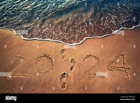Happy New Year 2024 concept written on the sea beach at sunrise Stock ...