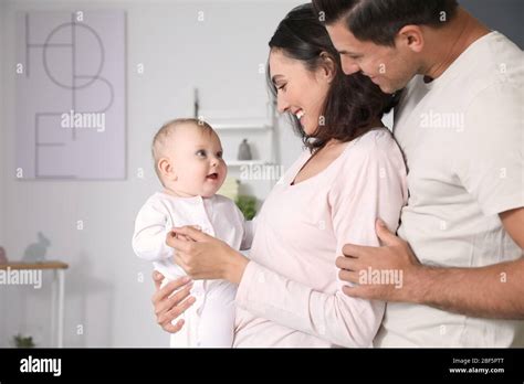 Cute baby with parents at home Stock Photo - Alamy