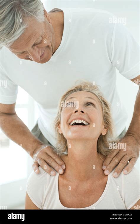 mature couple smiling     man massages womans shoulders
