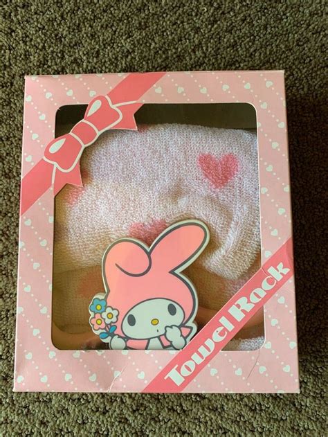 a pink hello kitty headband in a box on the floor next to a brown carpet