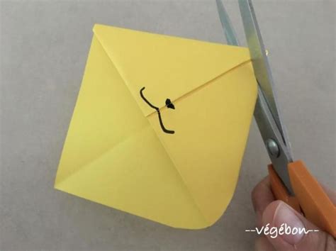 a person holding scissors and an origami envelope