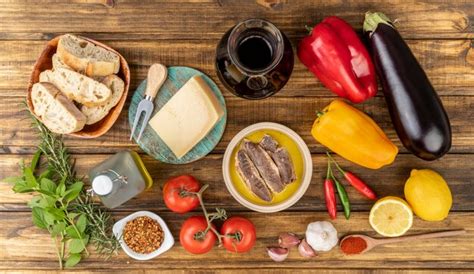 Legumes, azeite, pão, queijo, peixe e vinho e legumes sobre a mesa de