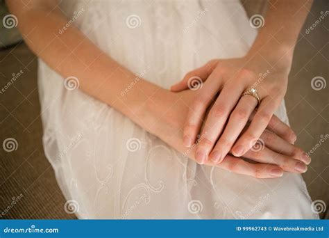midsection  bride wearing wedding ring  sitting  sofa stock