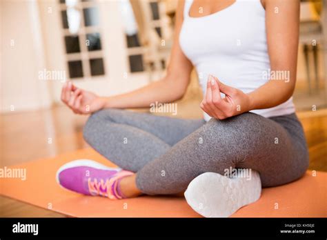 Young woman sitting on floor at home doing yoga meditation Stock Photo - Alamy