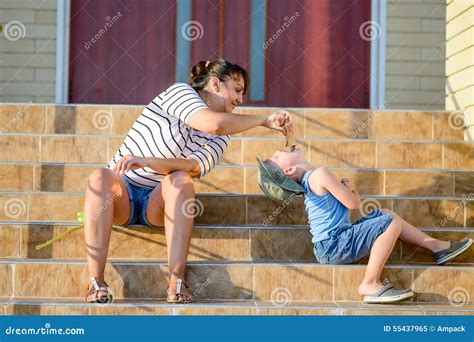 Mother Feeding Ice Cream To Son on Steps of Home Stock Image - Image of ...