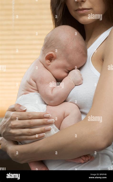 A mother holding her sleeping baby Stock Photo - Alamy