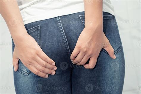 la femme souffrait d'hémorroïdes et a mis sa main sur ses fesses à