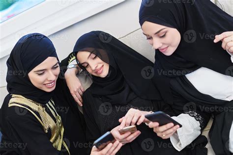 Portrait of Arabian girls wearing modern abaya using mobile phone