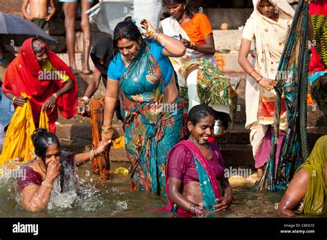 Indian Hindu pilgrims bathing in The Ganges River at Dashashwamedh Ghat ...