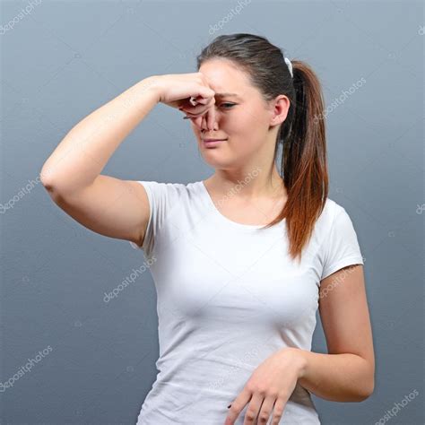 Portrait of woman covering nose with hand showing that something ...