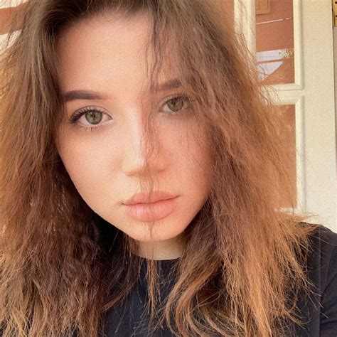 a close up of a person with long hair and green eyes looking at the camera