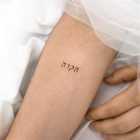 Lettering tattoo in hebrew on the inner forearm.