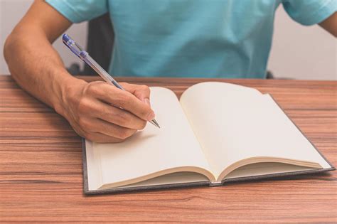 persona escribiendo un libro en un escritorio 2074436 Foto de stock en ...