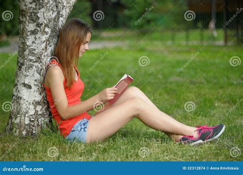 Девушка на траве с книгой стоковое фото. изображение насчитывающей ...
