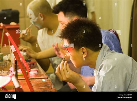 Chinese beijing opera performers applying their makeup before the ...