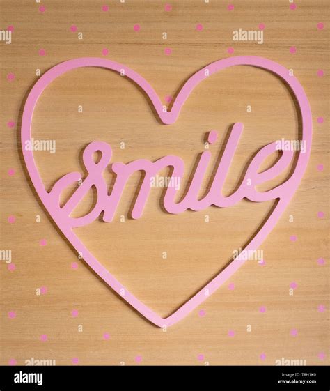 Signboard Smile inside a pink heart with wooden background. Be happy ...