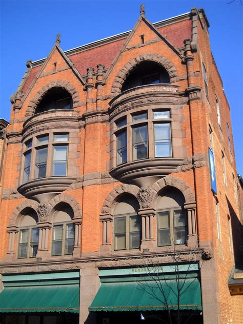 an old brick building with arched windows and green awning