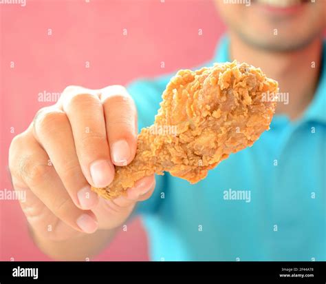A man giving fried chicken leg or drumstick Stock Photo - Alamy