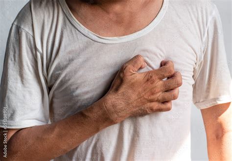Asian man suffering from left sided chest pain. Chest pain can be